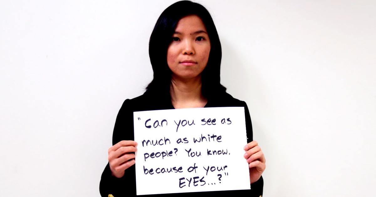 It is a photo of an Asian girl holding a paper that says "can you see much as white people you know because of your eye..."