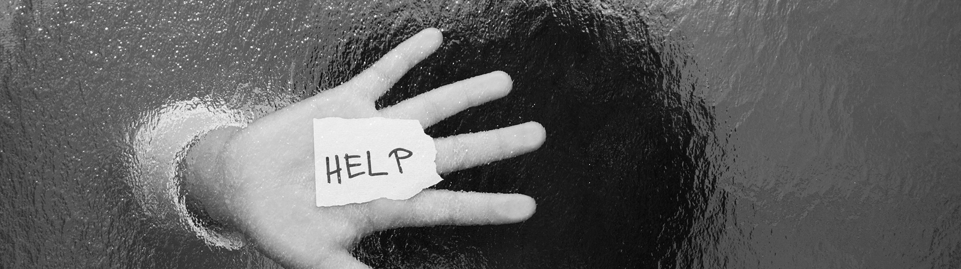 This is a picture of someone's hand with a paper written on it "HELP"
