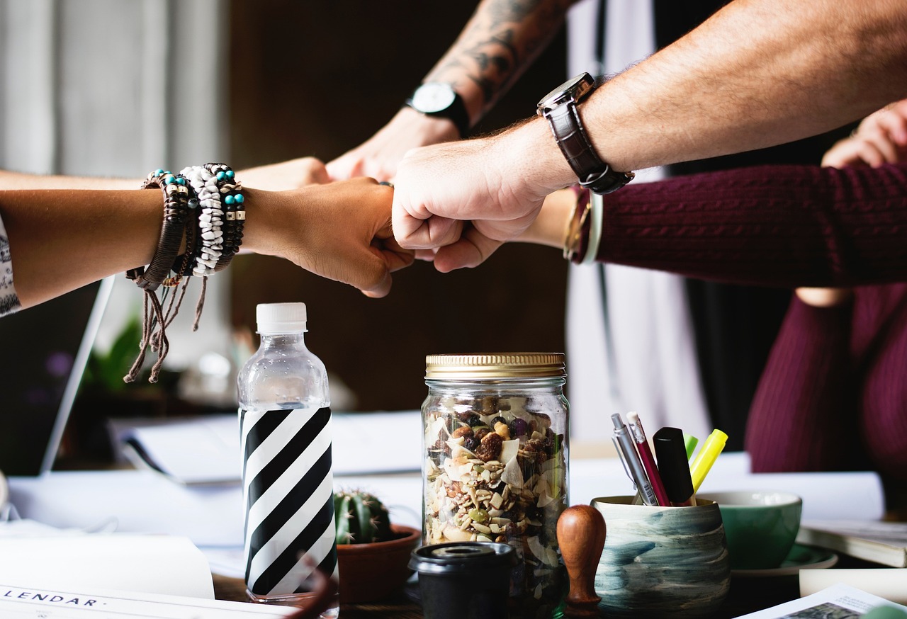 4 or 5 people fist bumping over a table
