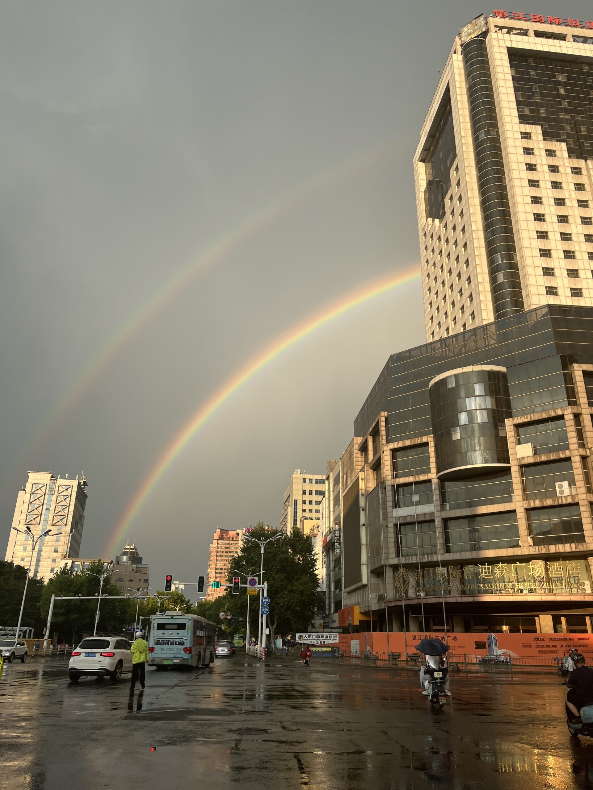 This is a picture of a rainbow and buildings in the streets of China.