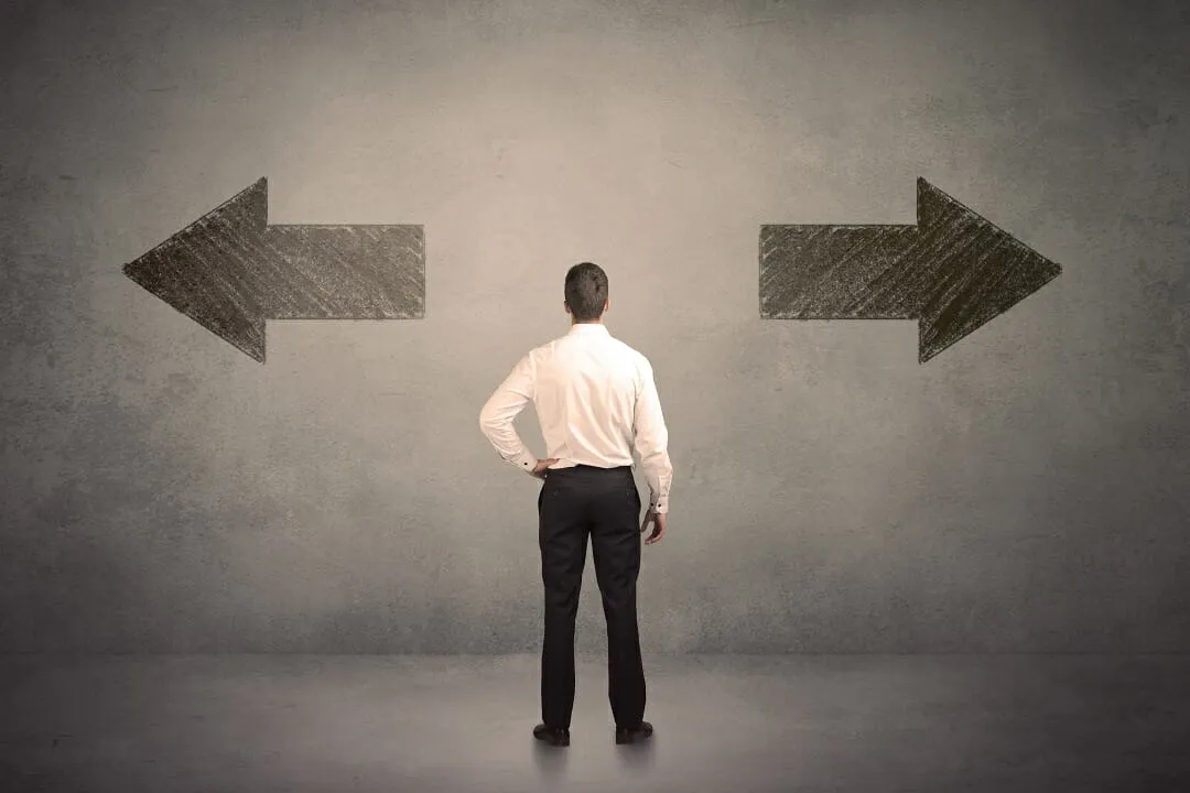 A man looking at an arrow pointing left and an arrow pointing right.